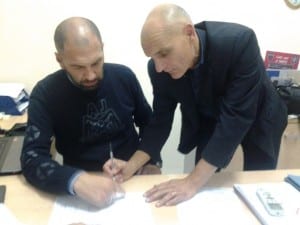 La firma del neo-tecnico Roselli sul contratto. Foto sito ufficiale www.ilcosenza.it